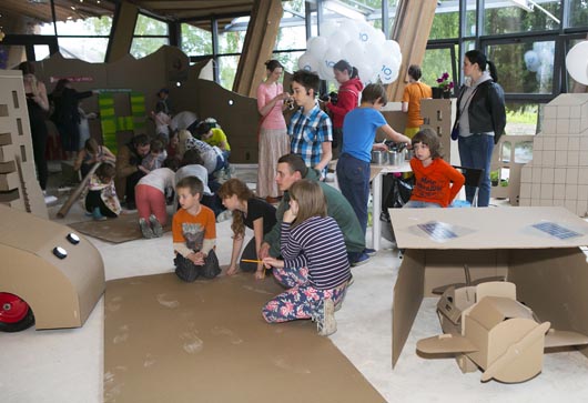 Дети помогают создавать наногород - картонная конструкция в зоне детских мастер классов