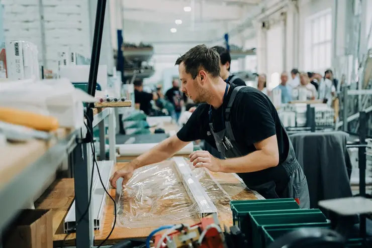 Сотрудник РЕХАУ упаковывает профиль, © РЕХАУ Сотрудник РЕХАУ упаковывает профиль, © РЕХАУ