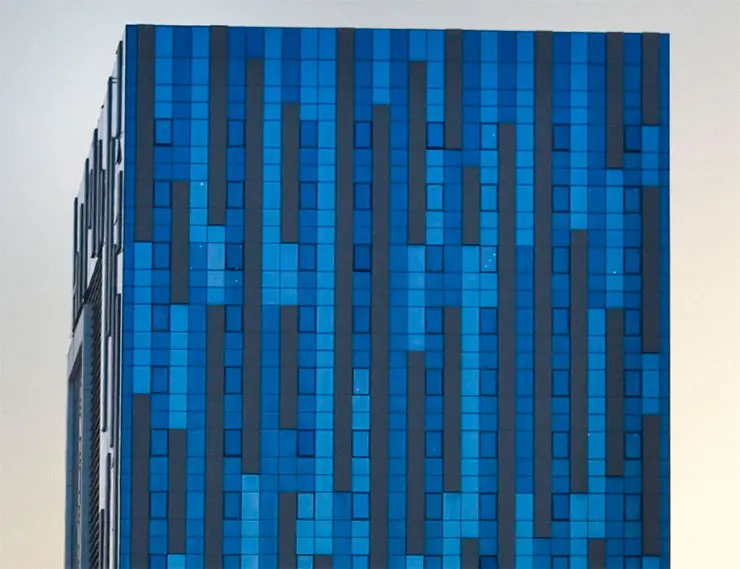Полностью стеклянные фасады голубых и серебристых оттенков подчеркивают графический орнамент на верхних уровнях здания